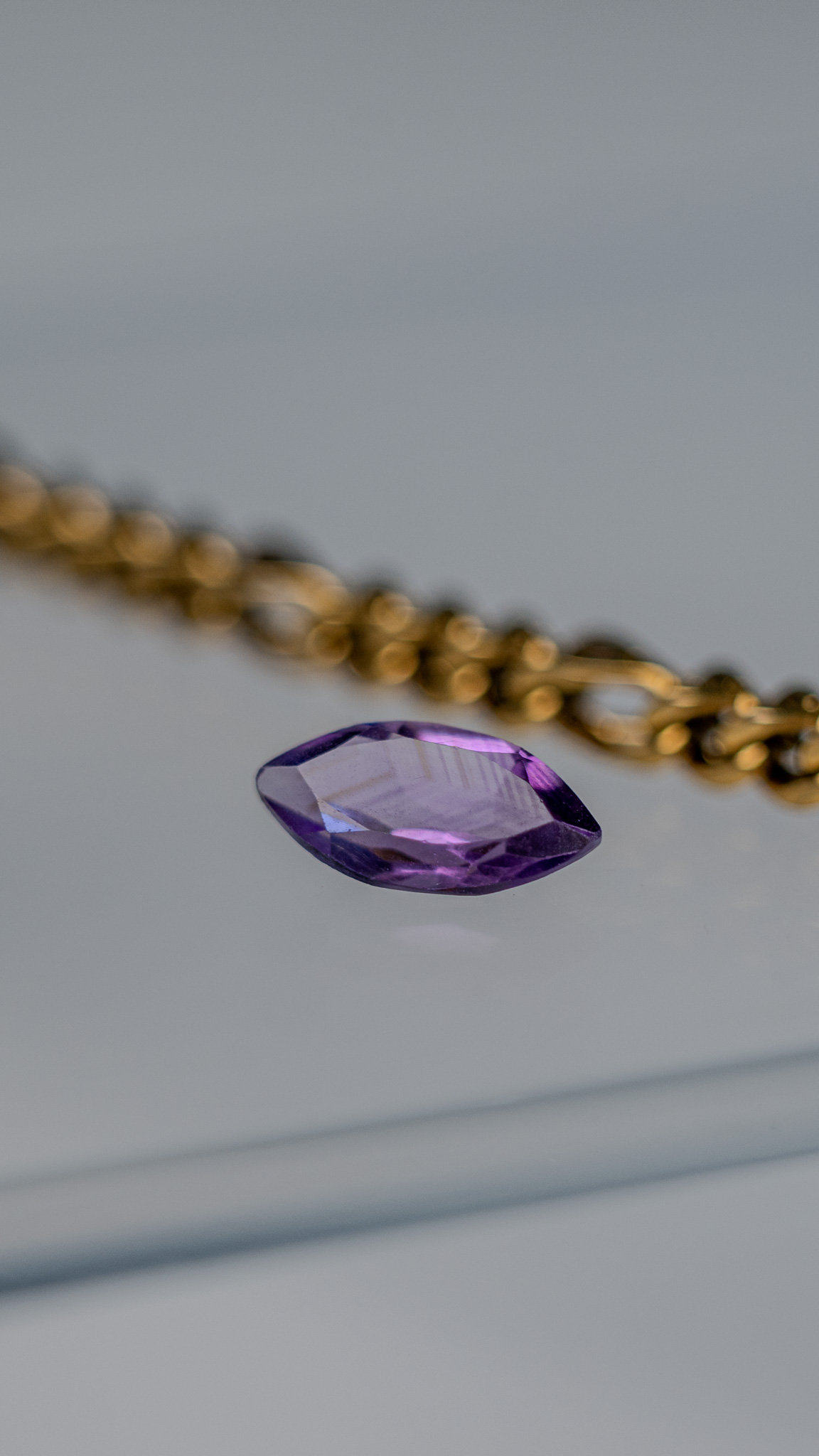 Loose natural marquise-cut amethyst on glass