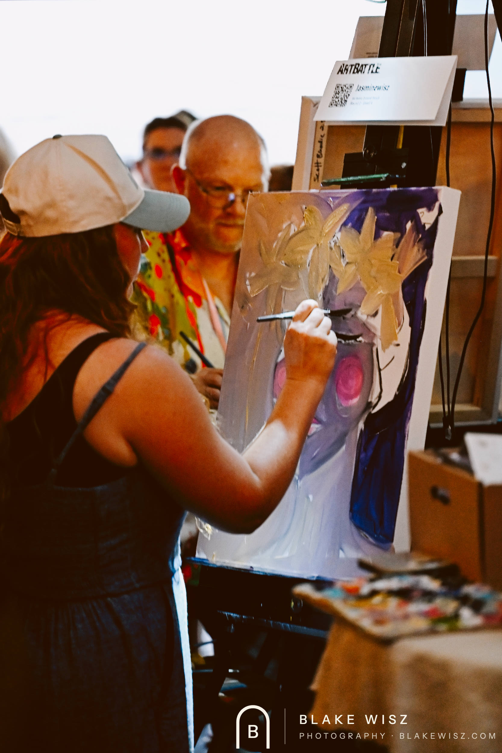 Jasmine Wisz painting her violet portrait with a lily crown at Art Battle Ormond Beach