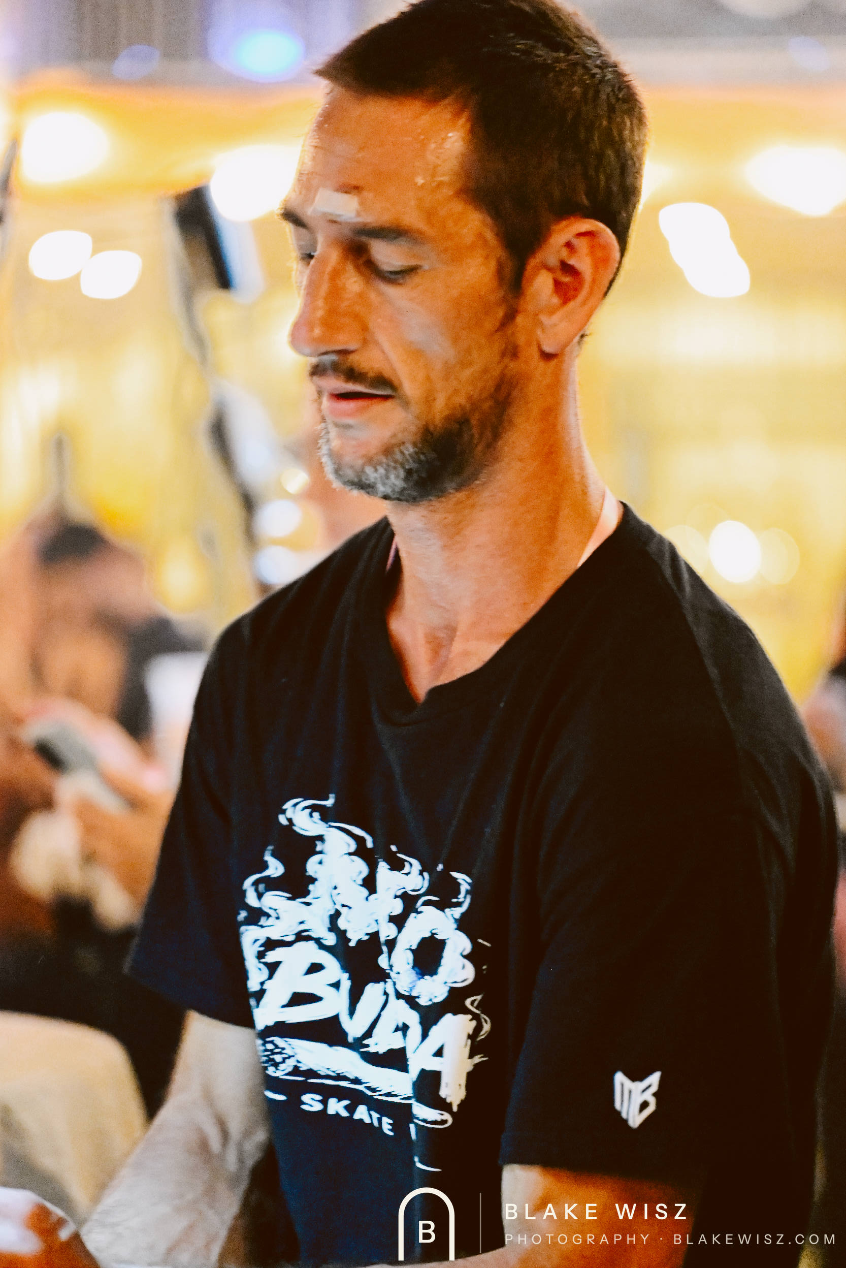 Spectator in a black skate tee watching the painting rounds at Ormond Brewing