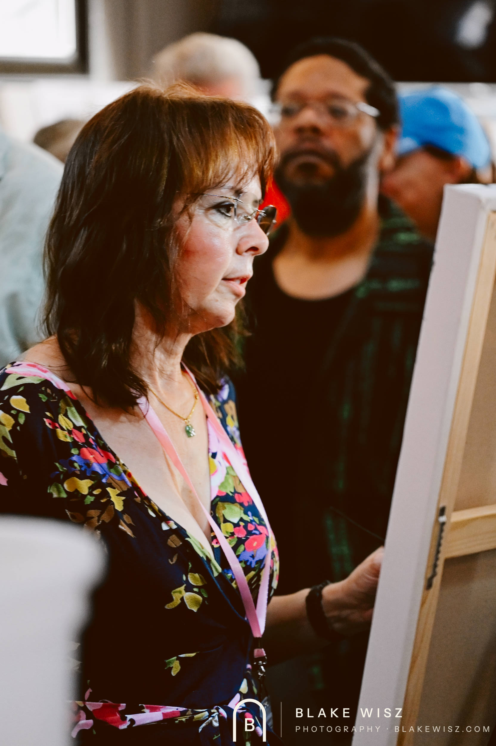Spectator in a floral dress watching a twenty minute painting round at Ormond Brewing