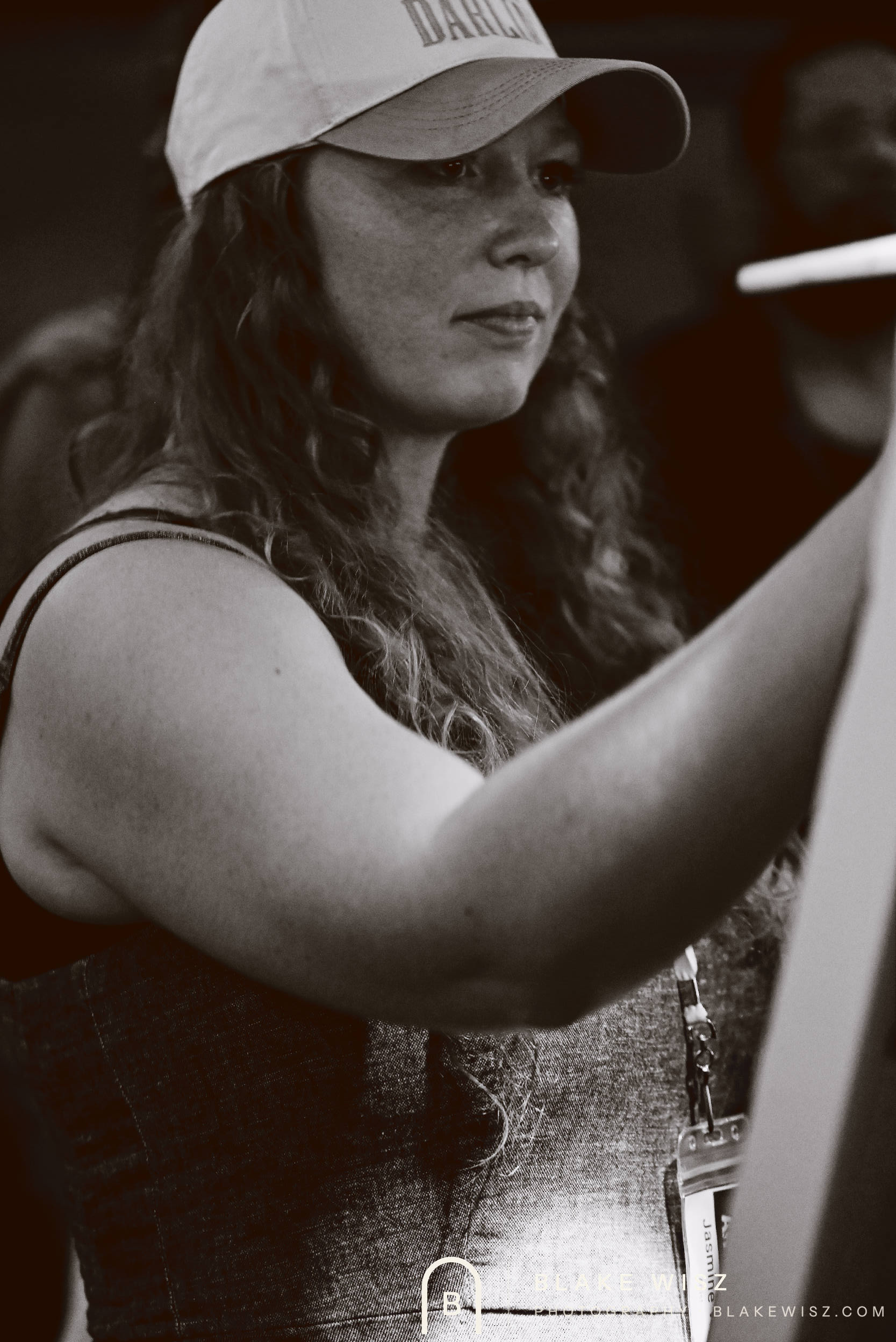 Black and white portrait of Jasmine Wisz painting at her easel during a timed round