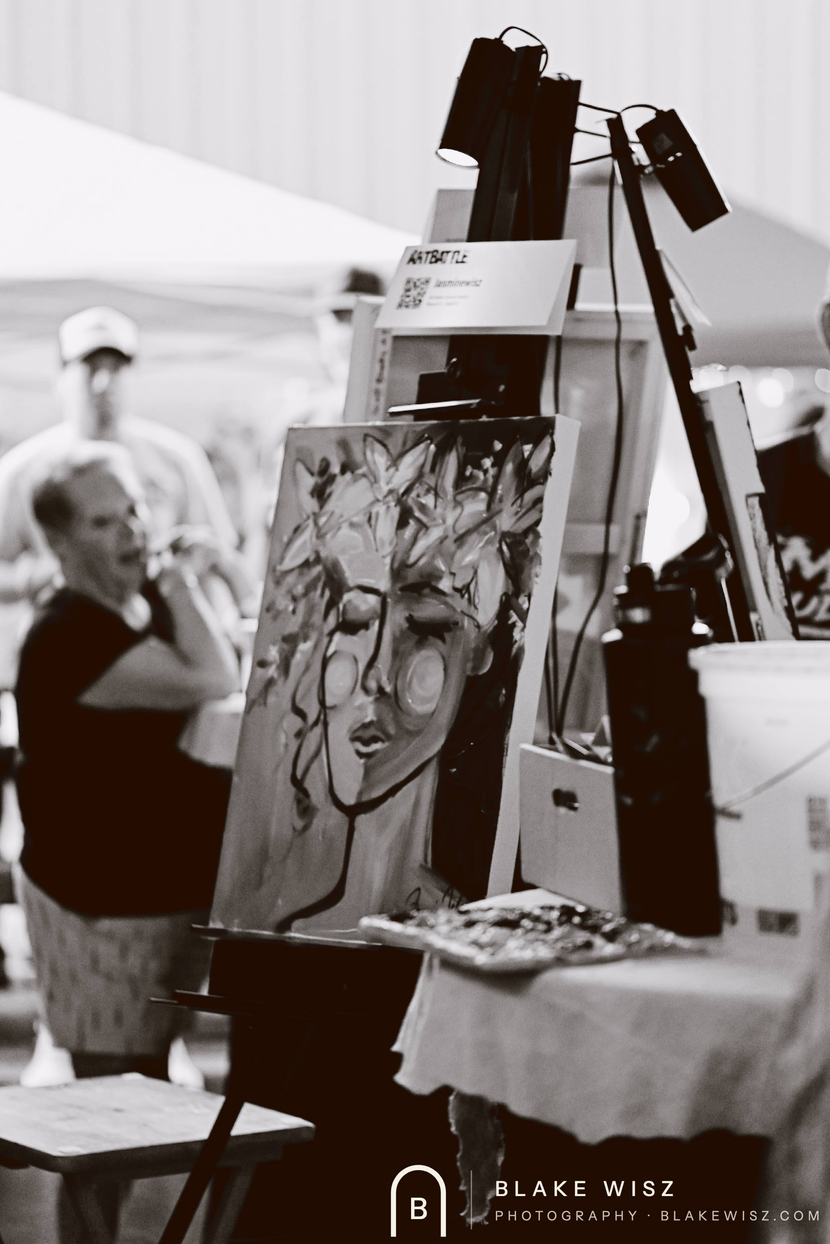 Black and white photo of a finished Art Battle canvas lit on its easel