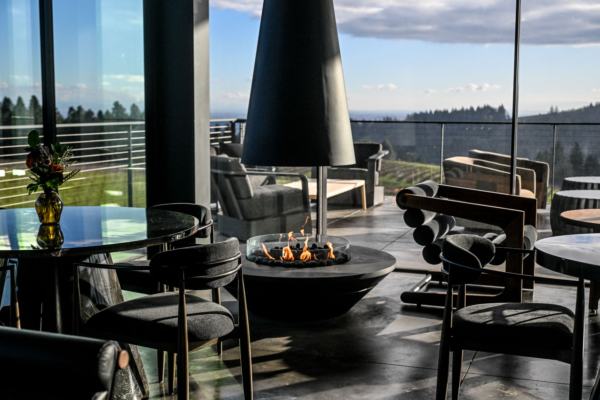 Cone shaped suspended fireplace in the glass walled lounge at LucidWild Estate