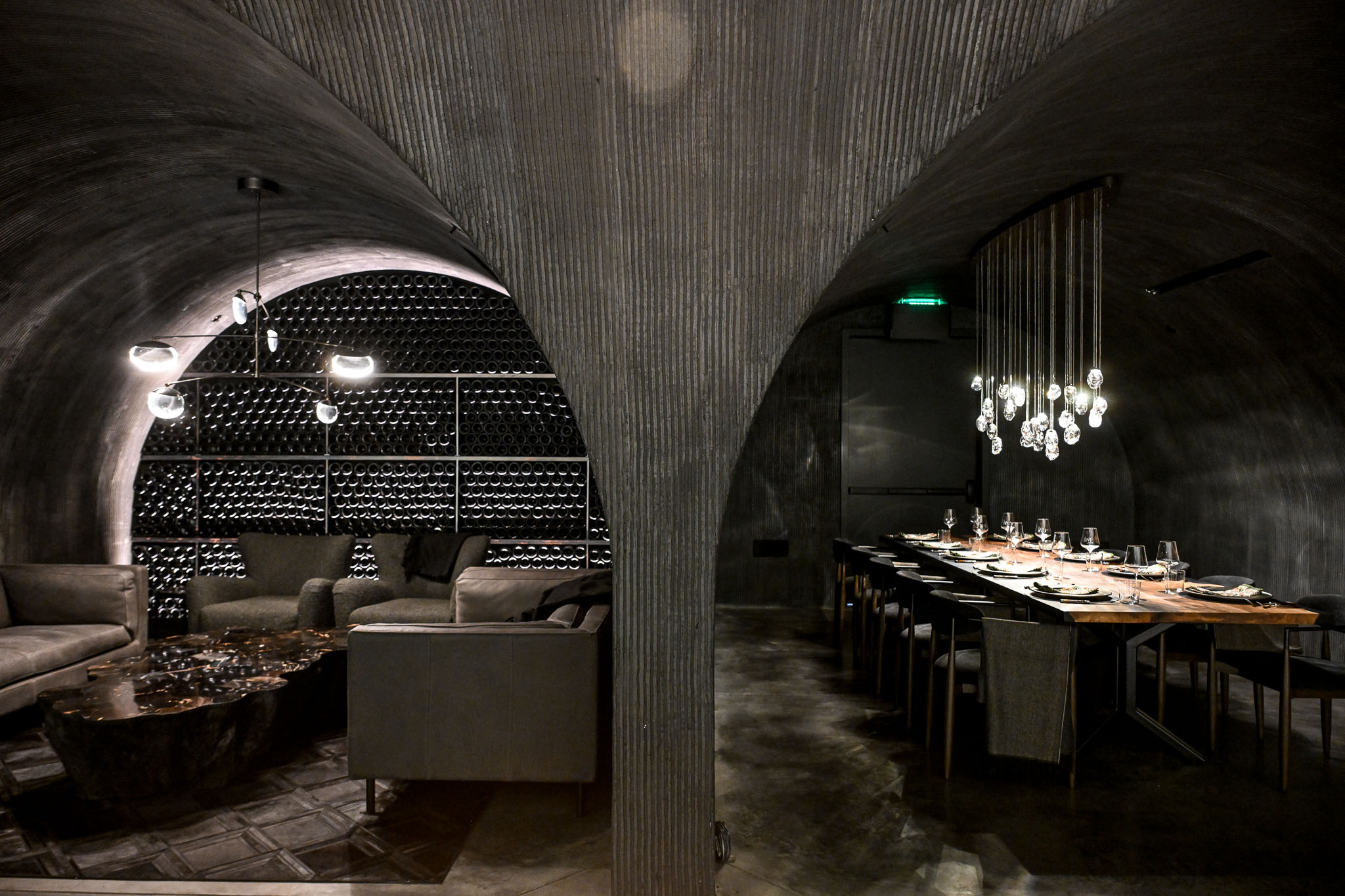 Vaulted underground wine cave at LucidWild Estate with racked bottles and lounge seating