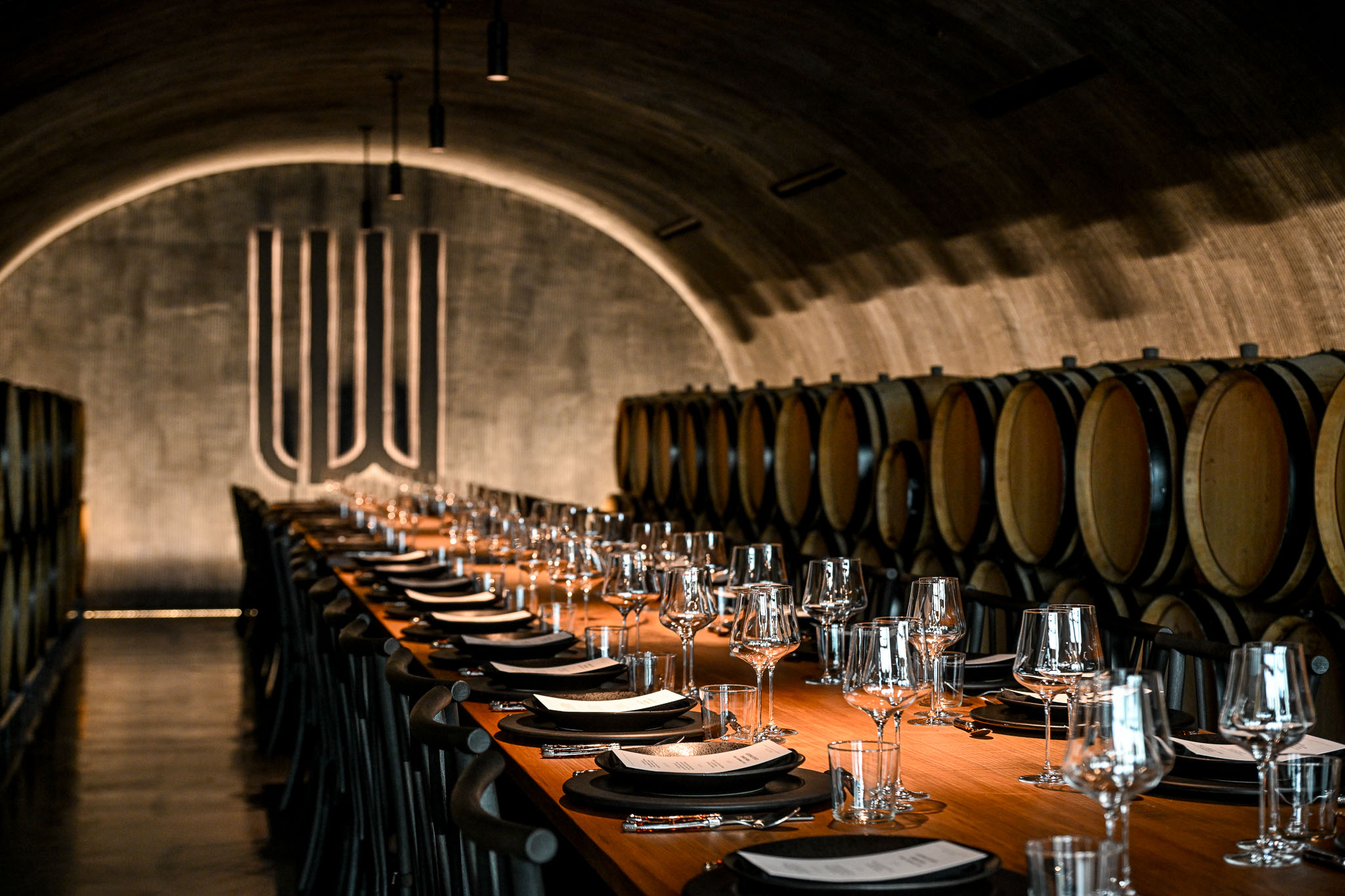 The barrel lined wine cave dining table at LucidWild Estate seen from its far end