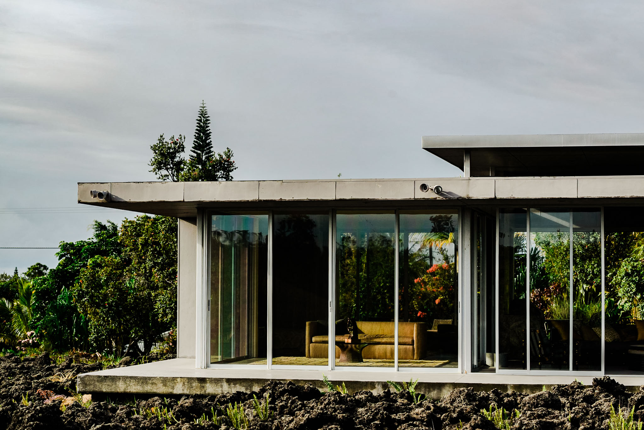 The glass living room of Lavaflow 1 seen across the black lava field