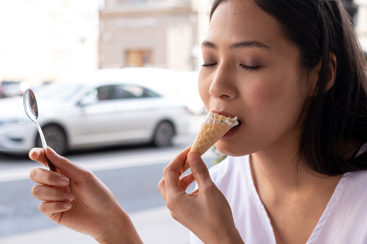 Woman with sensitive teeth eating ice cream.