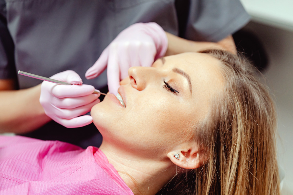 Woman with dead tooth receiving dental treatment.
