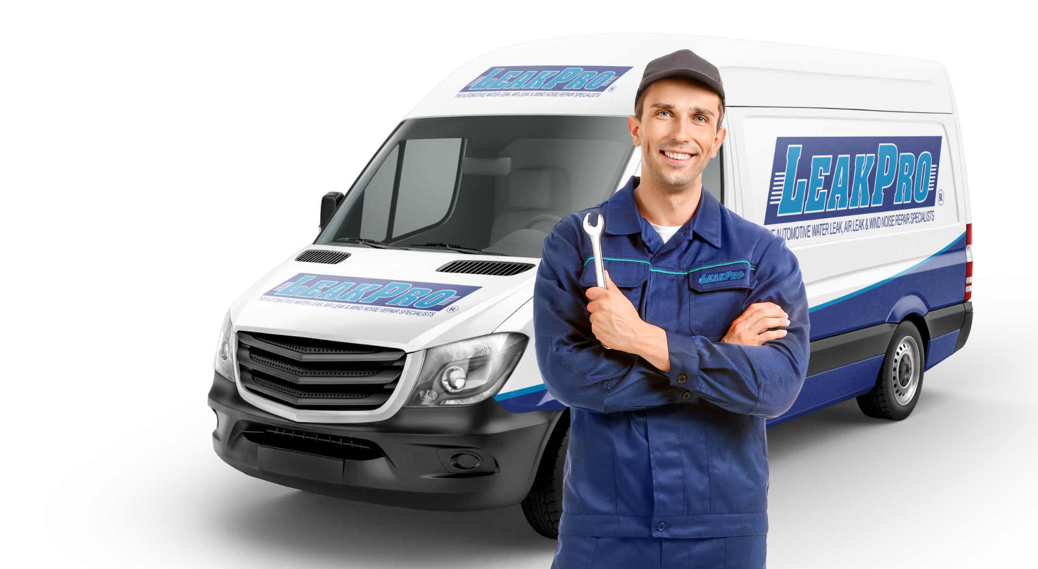 A mechanic in a blue jumpsuit in front of a LEAKPRO van holding a wrench and smiling