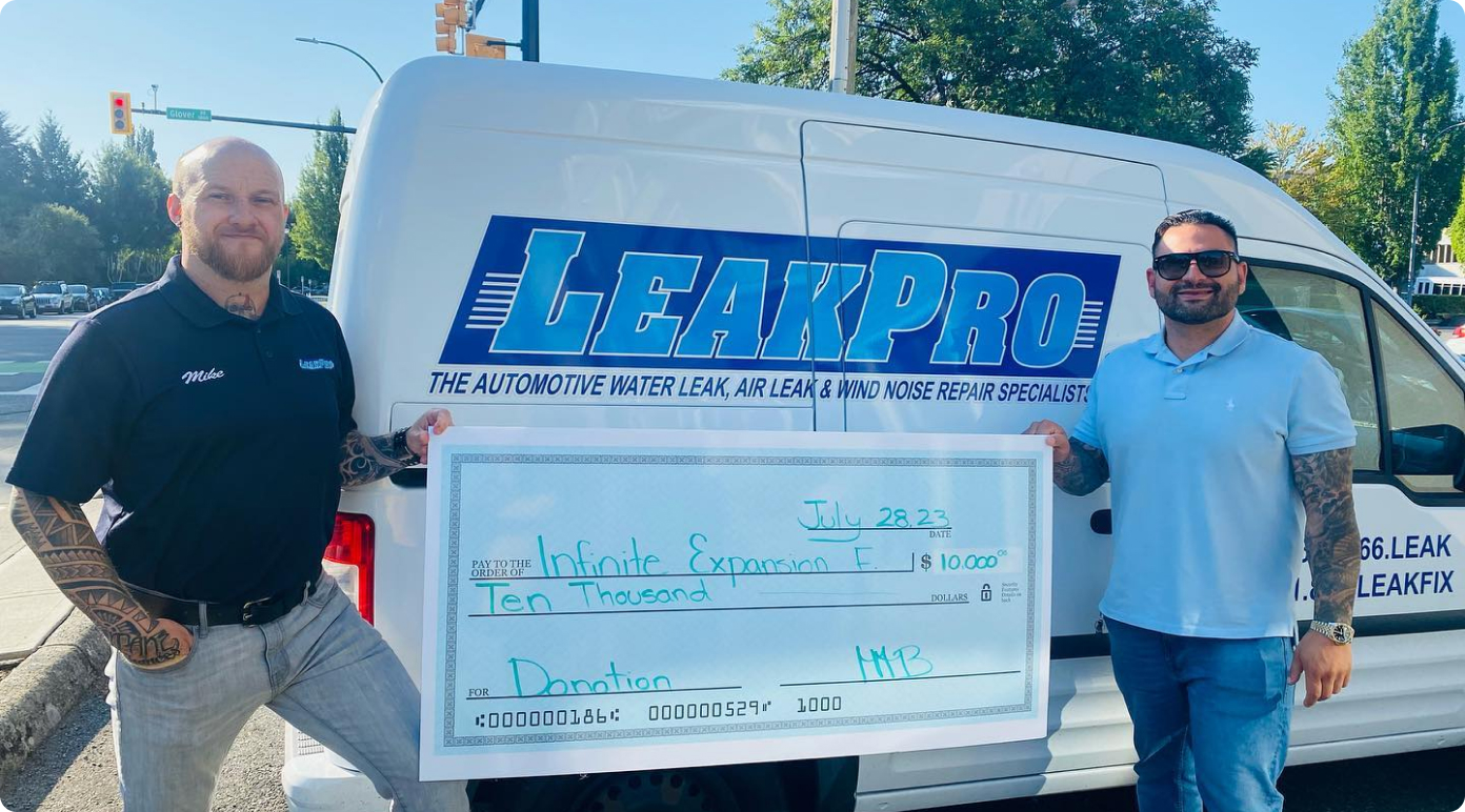 LEAKPRO President Michael MB holding a large cheque for $10,000 made out to Infinite Expansion