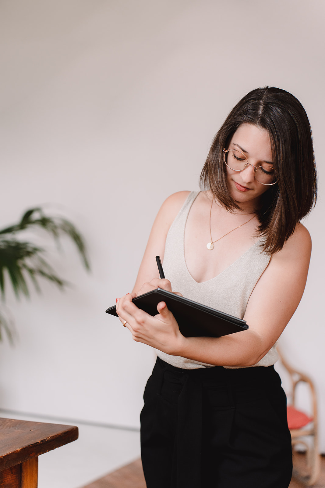 Céline debout, écrit sur son carnet digital. Concentrée, elle pose ses mots.