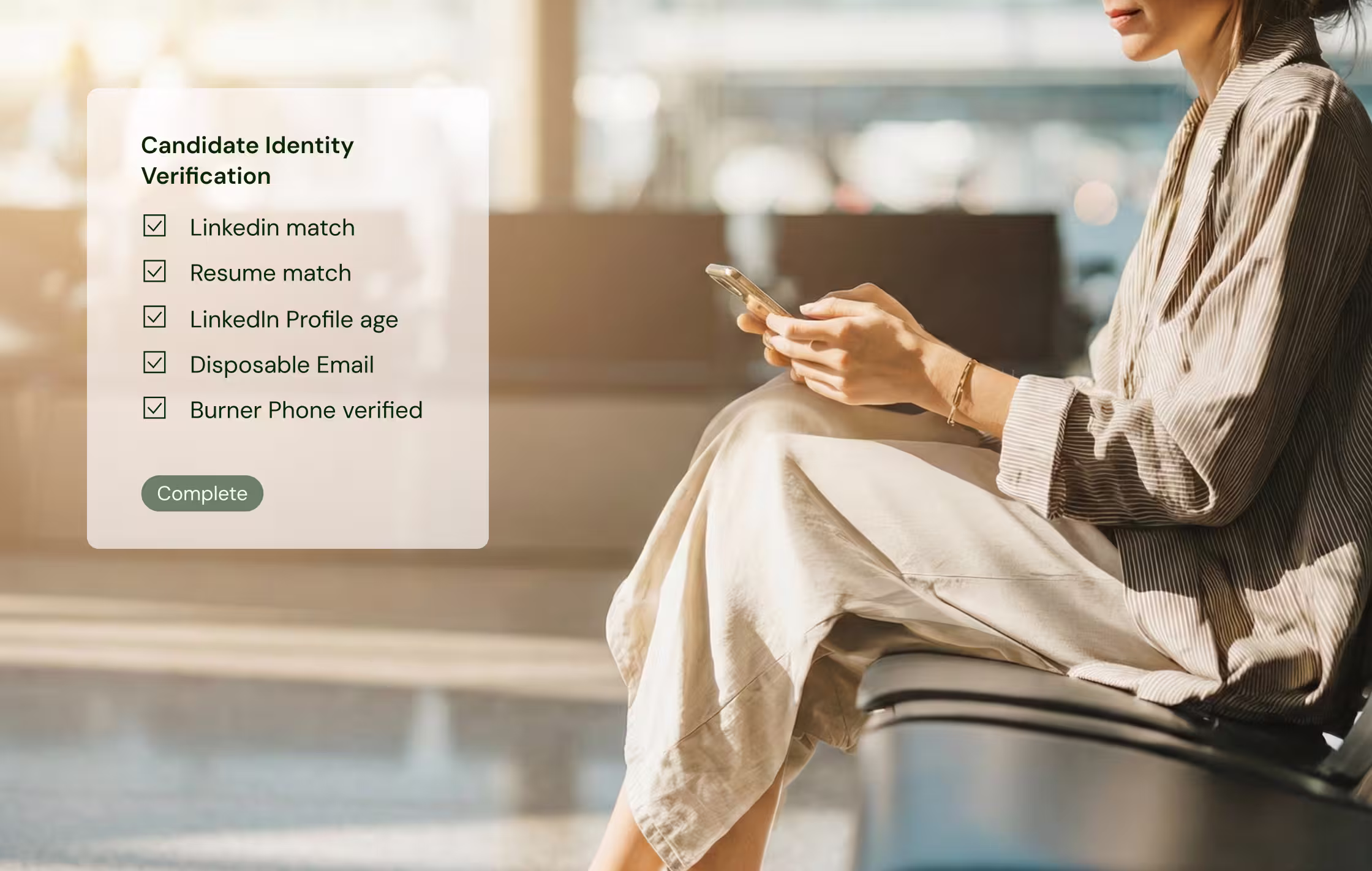 Woman sitting on a chair indoors, holding a smartphone, next to a checklist titled Candidate Identity Verification with all items checked and a Complete button.