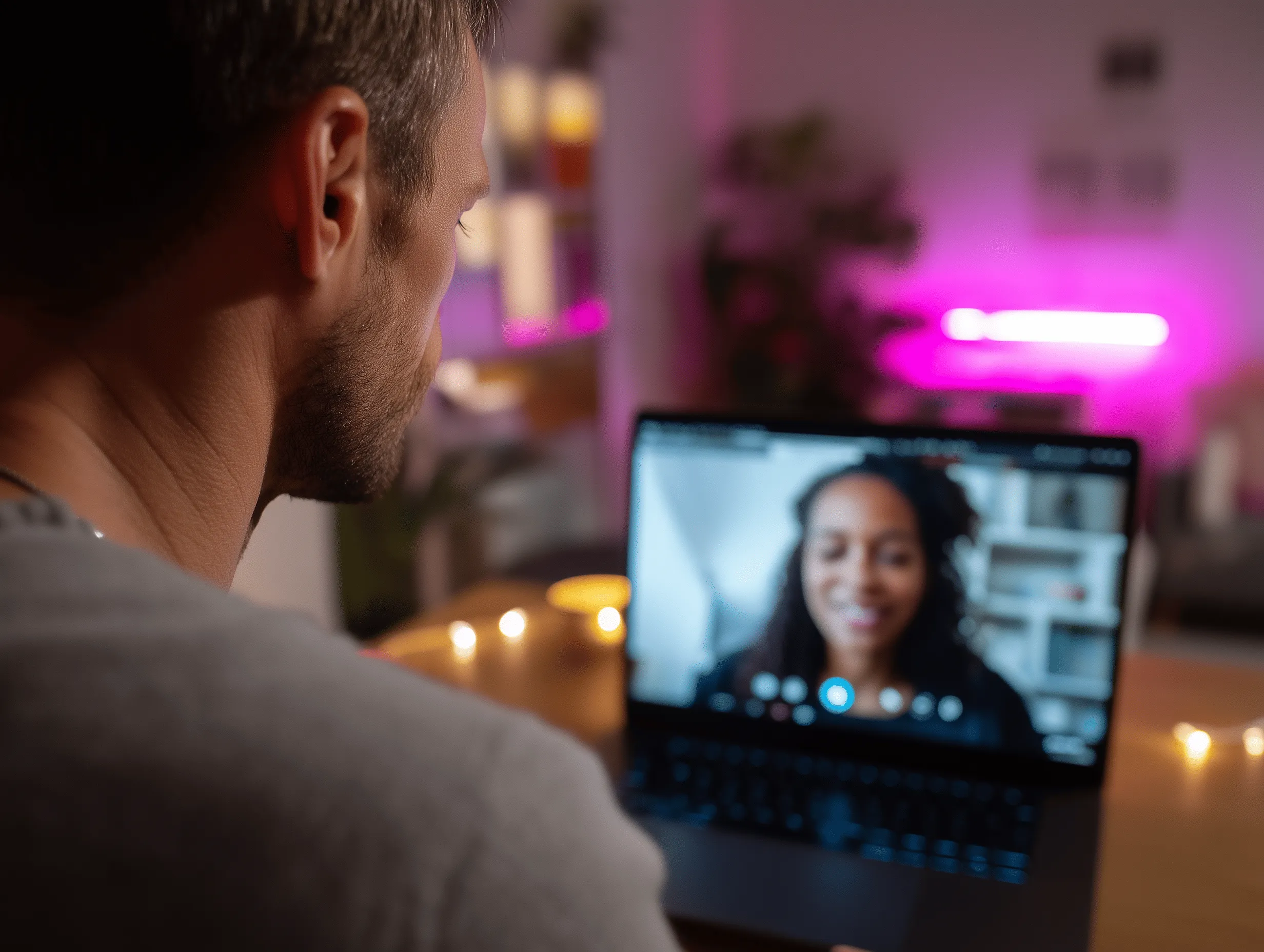Person having a video call in a cozy, pink-lit room at night