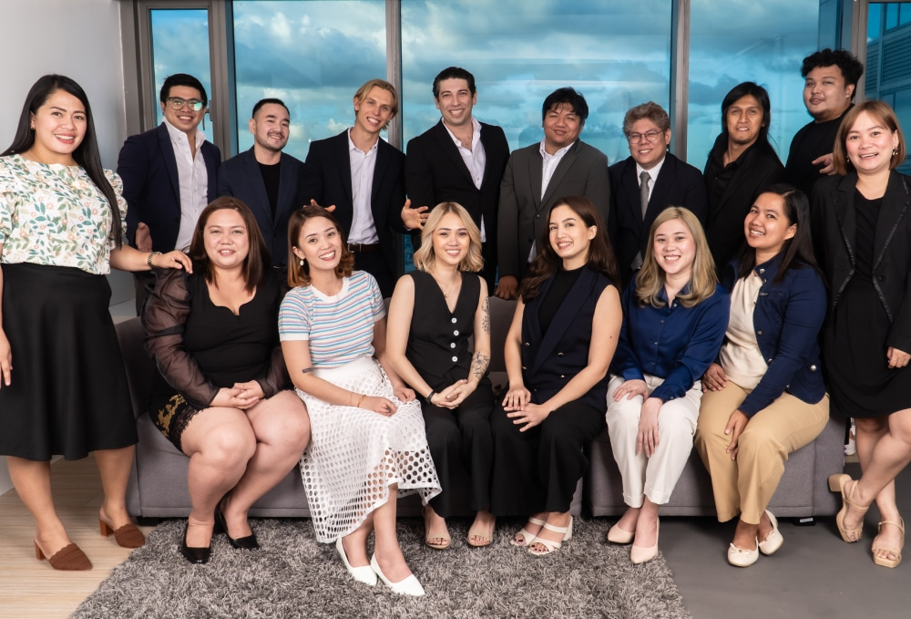 Diverse team of professionals posing together in an office with large windows