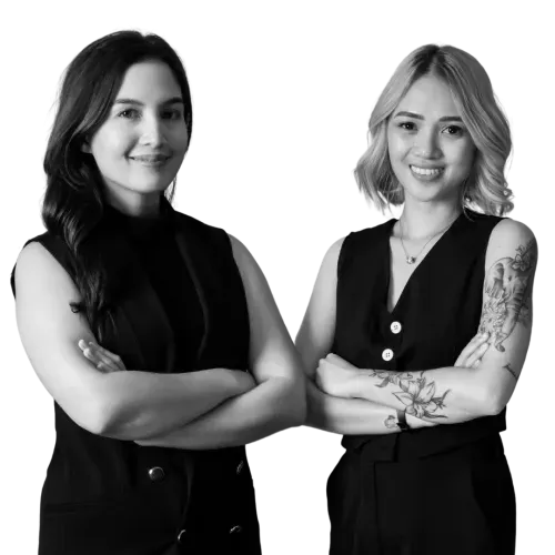 Two professional women in black outfits posing with crossed arms