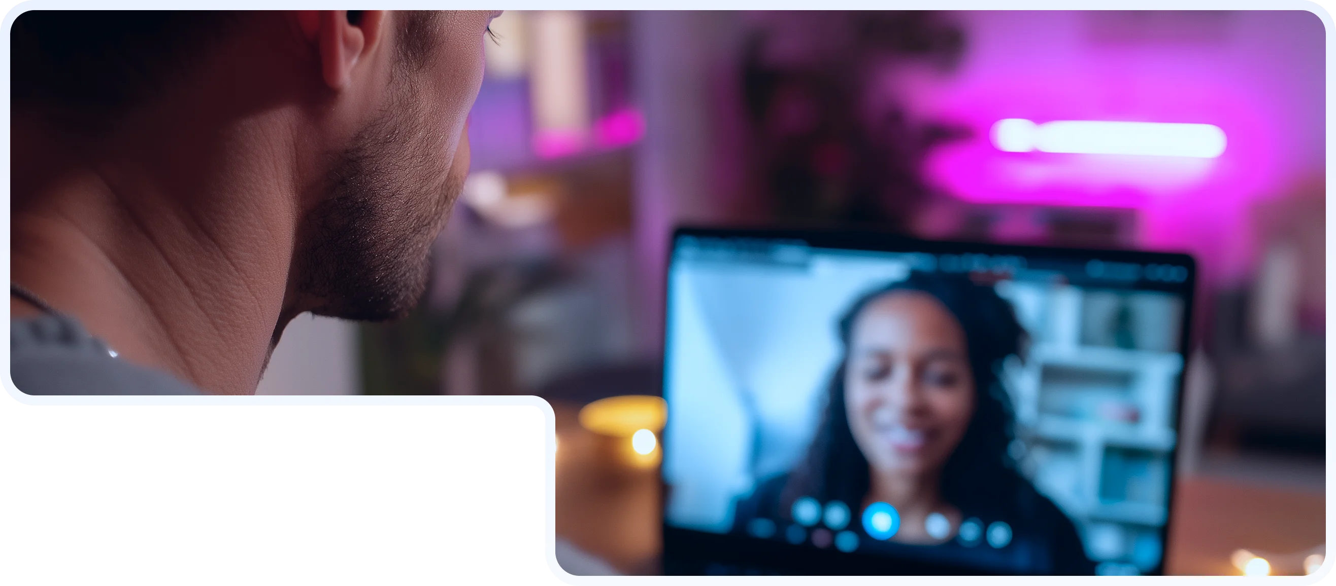 Man viewed from behind participating in a video call with a smiling woman on the laptop screen in a dimly lit room with purple ambient lighting.