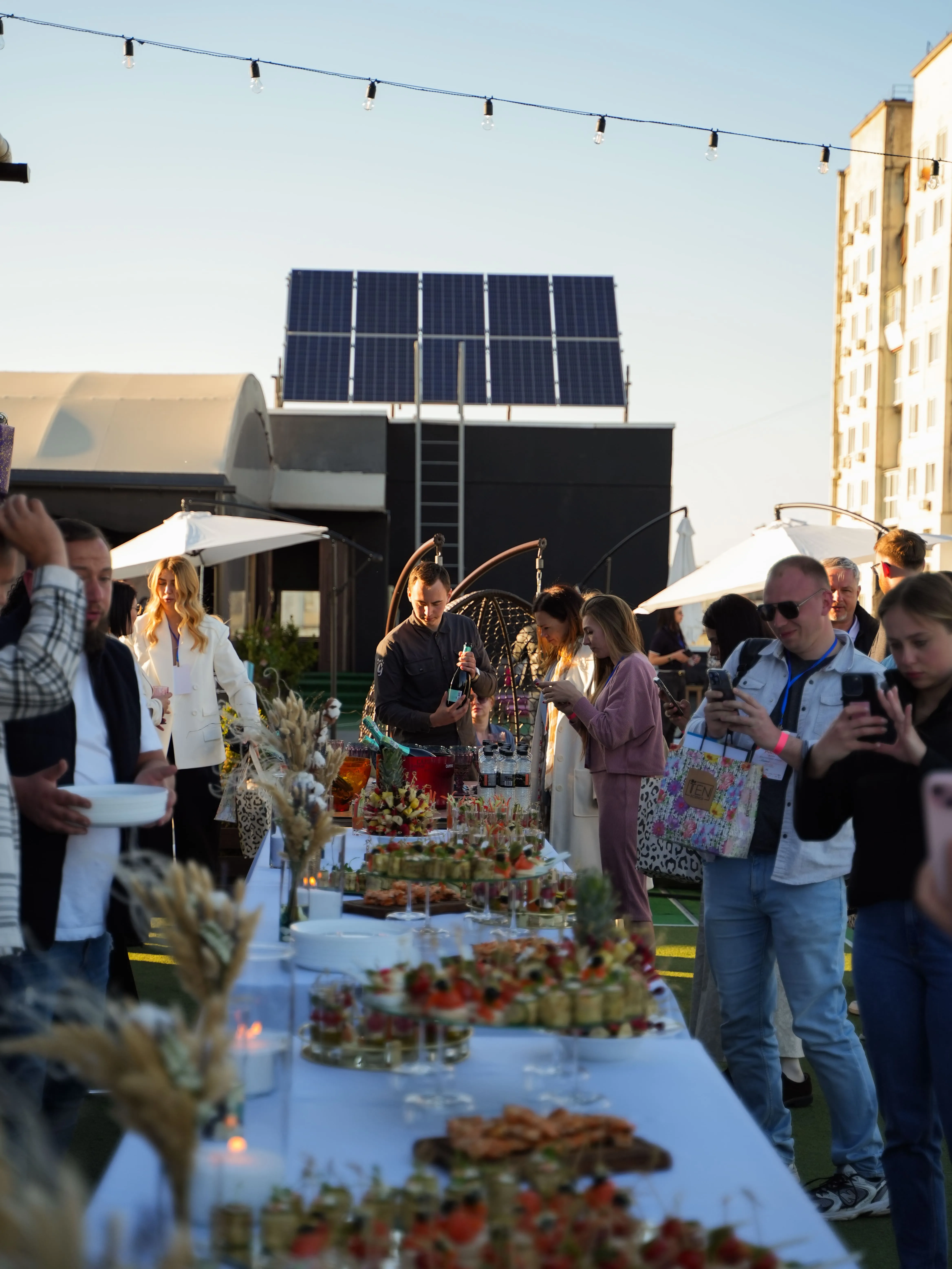 Гості на вечірньому заході біля фуршетного столу