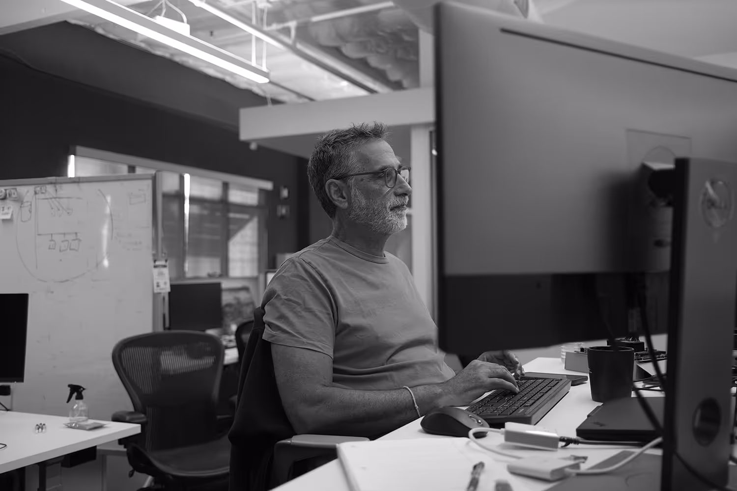 Tensordyne employee in office at desk in front of a monitor.