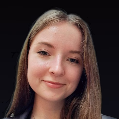 Young woman with long straight light brown hair smiling gently against a black background.