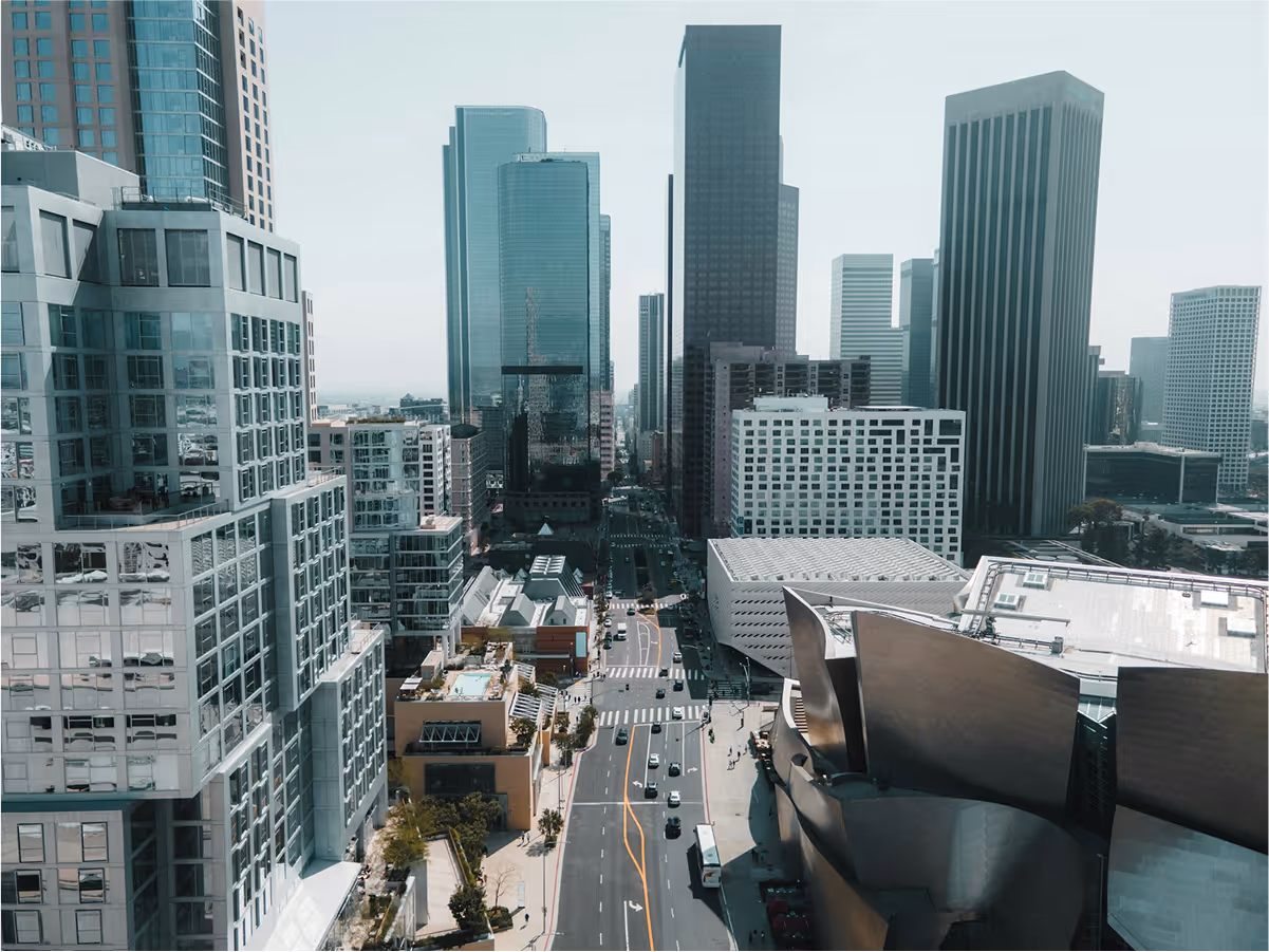 Aerial view of downtown cityscape with tall skyscrapers and a busy street.