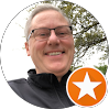 Smiling IT professional outdoors with orange star rating badge overlay for Red Team IT managed services