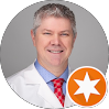 Male IT professional in white lab coat with orange star badge icon overlay
