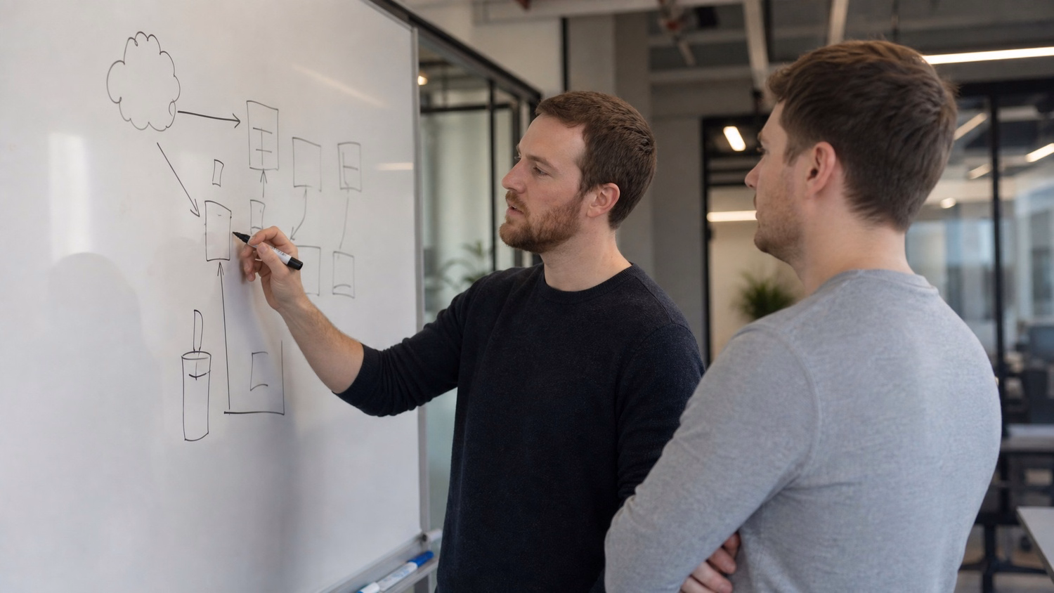 WHITEBOARD SESSION An IT professional one or two people standing at a whiteb