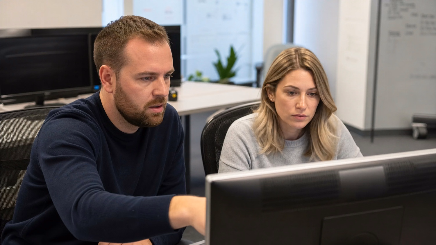 SIDE-BY-SIDE PAIR An IT professional two people seated side by side reviewin