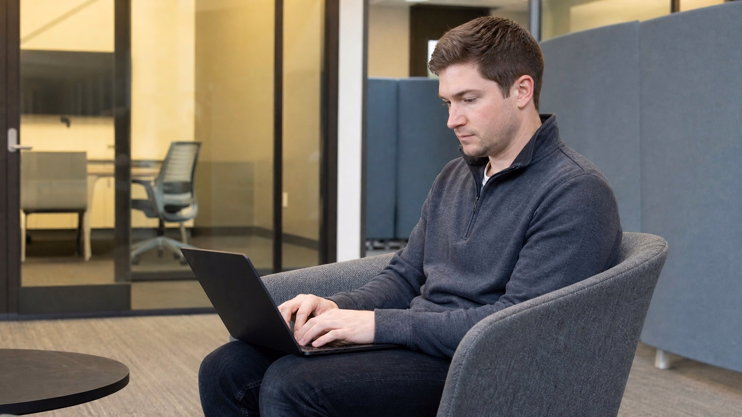 LOUNGE AREA LAPTOP one person working on a laptop in a casual office lounge wi