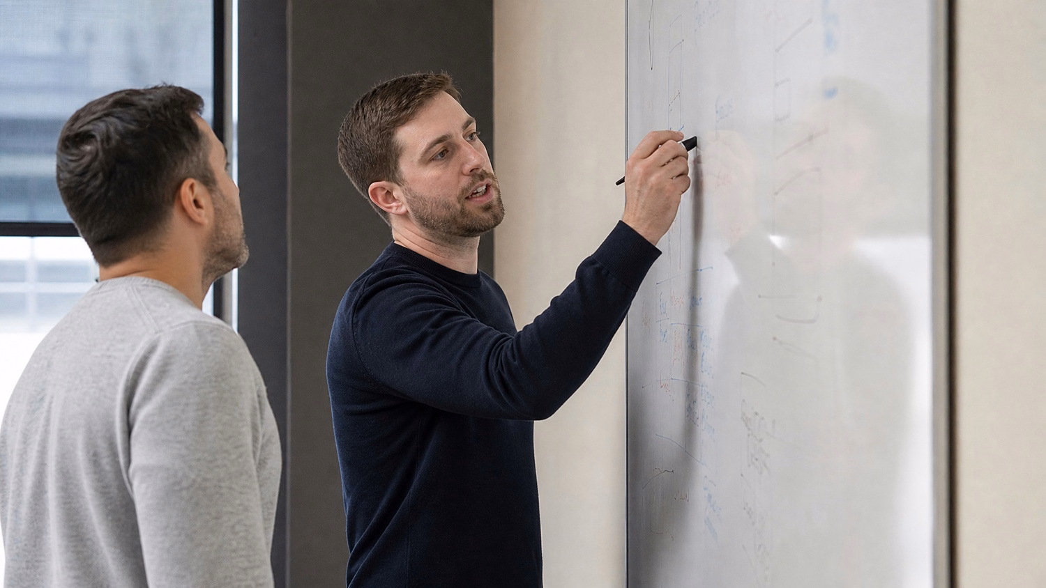 WHITEBOARD SESSION An IT professional one or two people standing at a whiteb