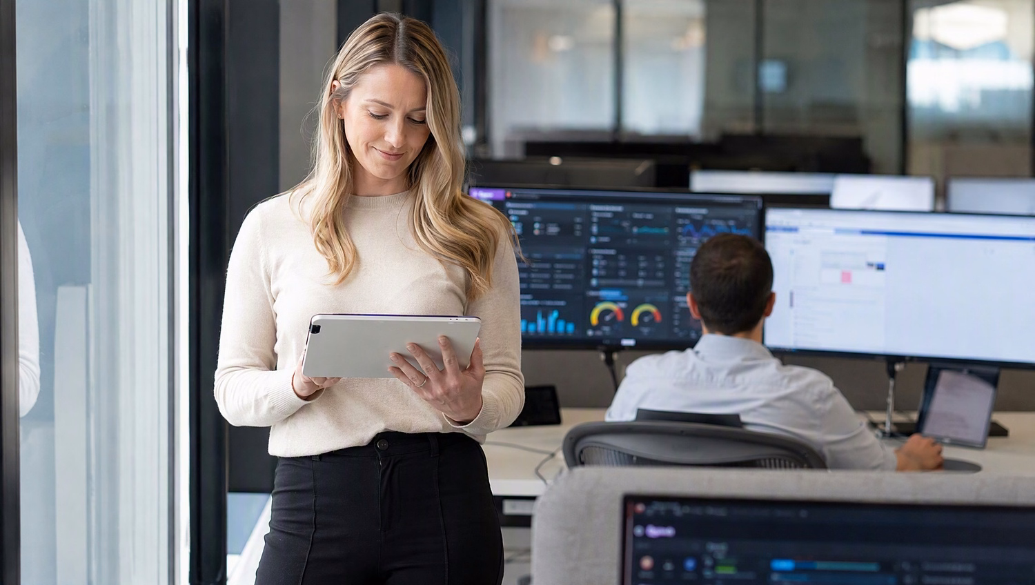 Woman reviews user accounts list on tablet near window 59