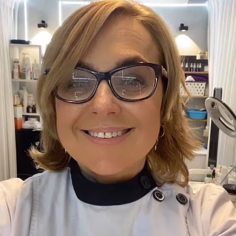 testimonial image of the cosmetologist smiling with the cosmetics shop on background.