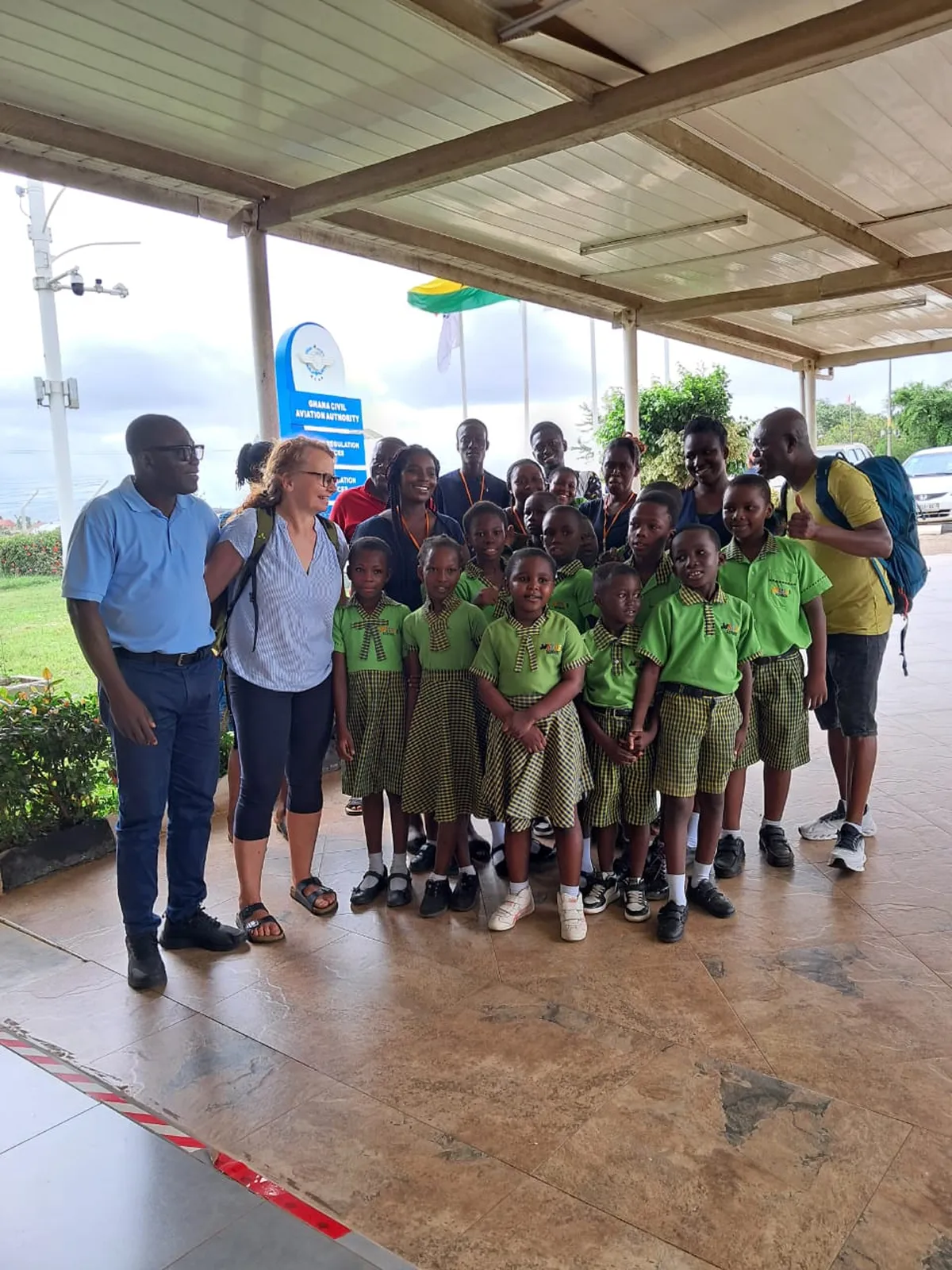 Gruppe von Kindern und Erwachsenen der Joy Stars School am Flughafen, gemeinsam für ein Erinnerungsfoto