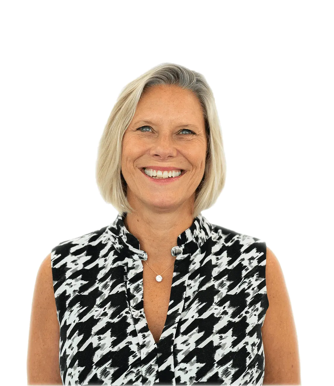 Smiling middle-aged woman with short blonde hair wearing a sleeveless black and white patterned top.