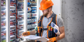 Profesionalni električar radi na zameni električnih kablova i uređaja