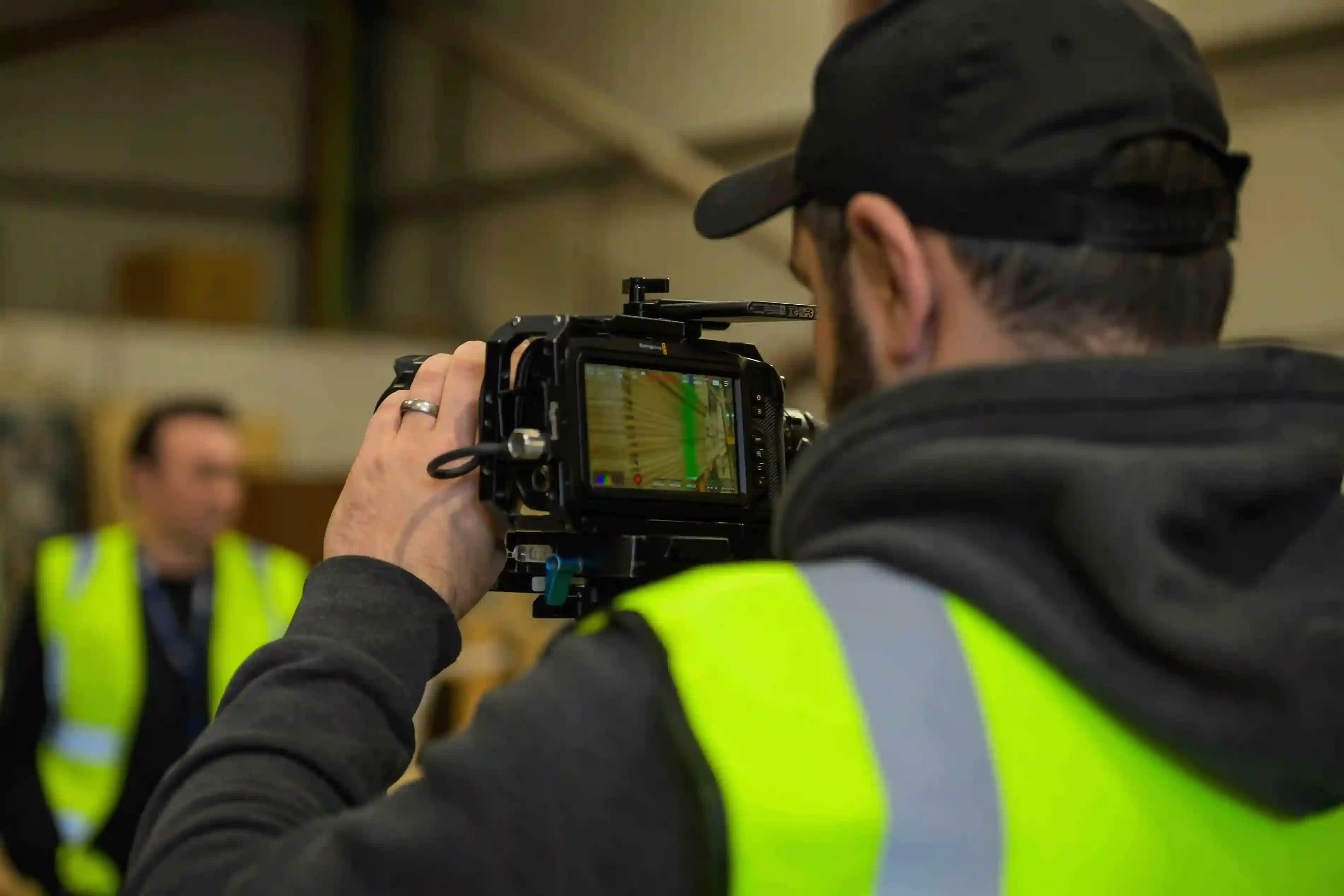 Videographer filming an interview on-site in an industrial workplace