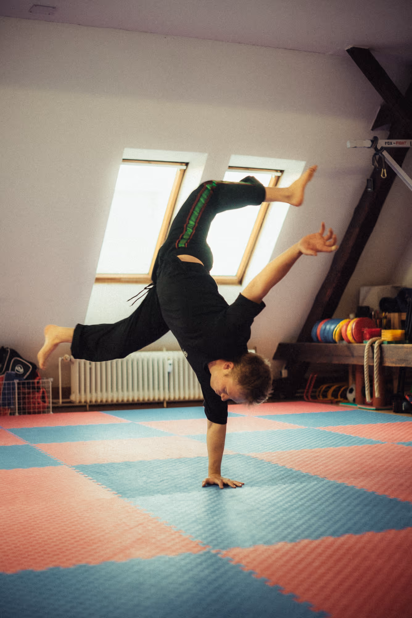 Teilnehmerer trainiert Soft Acrobatics auf der Matte in der Kampfkunstschule Neukölln.