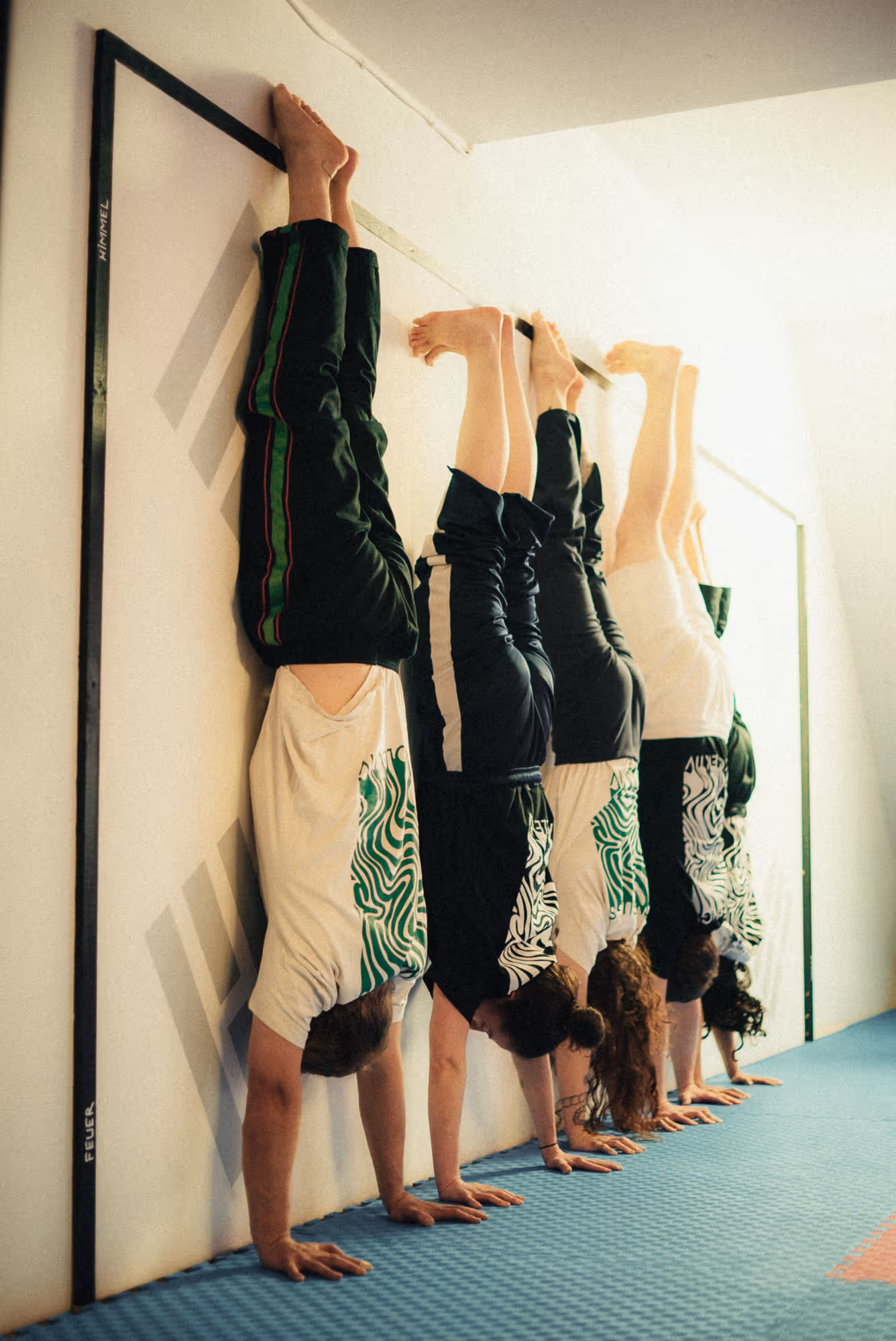 Gruppe beim Handstandtraining an der Wand im Movement Workshop Berlin-Neukölln