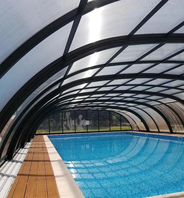 Überdachter Pool mit klarem Wasser und Holzboden, genutzt für Training und Erholung im Movement Camp.