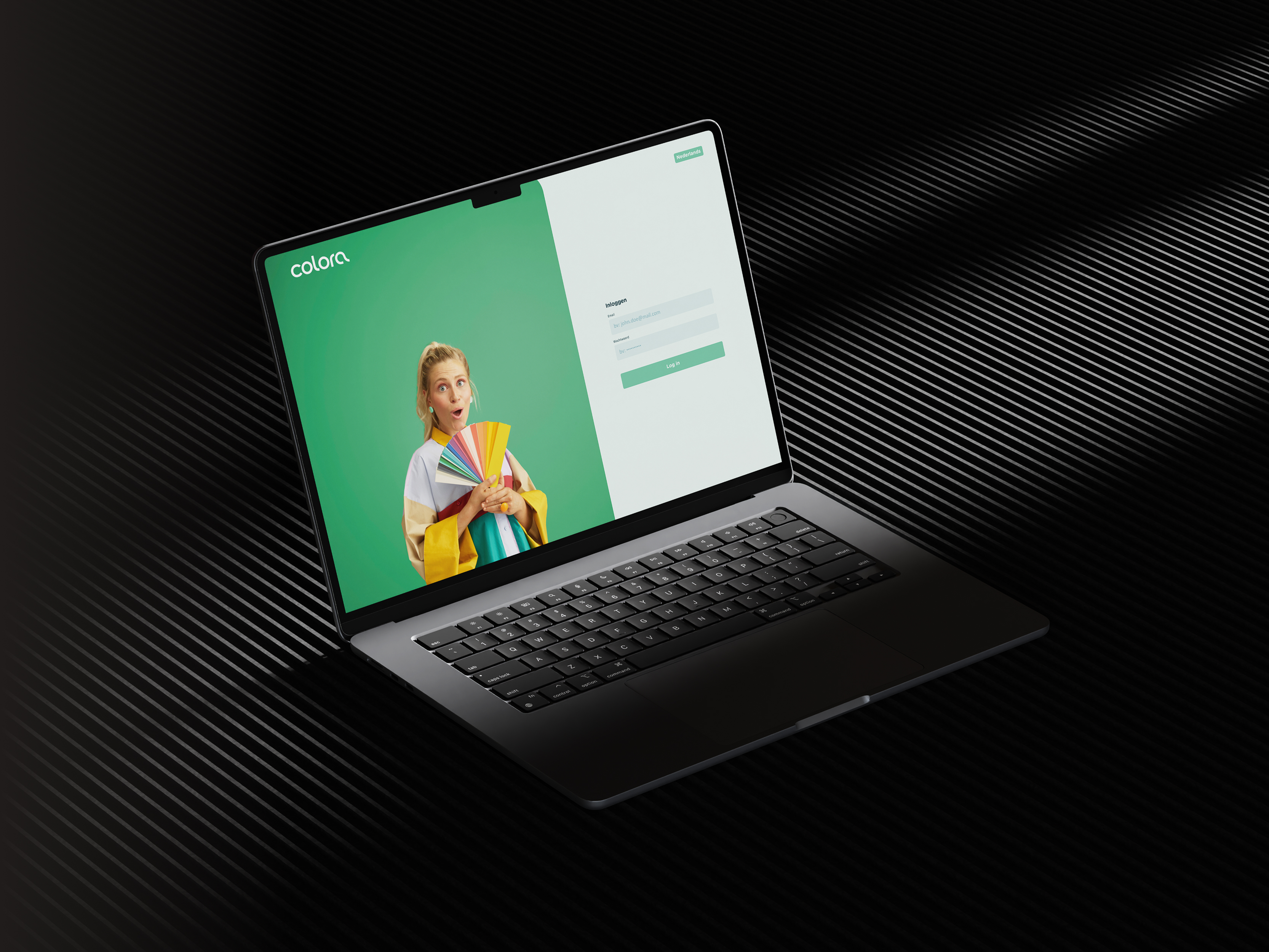 Laptop met aanmeldscherm van de Colora-website, met een vrouw die kleurstalen vasthoudt op een groene achtergrond.