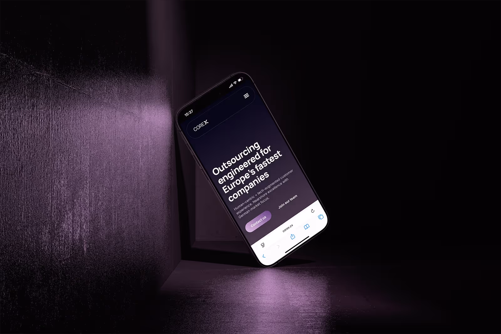 Smartphone floating in a dark purple-lit room displaying a website for outsourcing services aimed at Europe's fastest companies.
