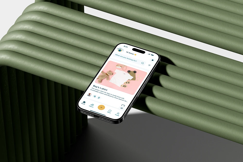 An iPhone resting on a green tubular structure displaying the YoungPlanet app homepage with a featured listing