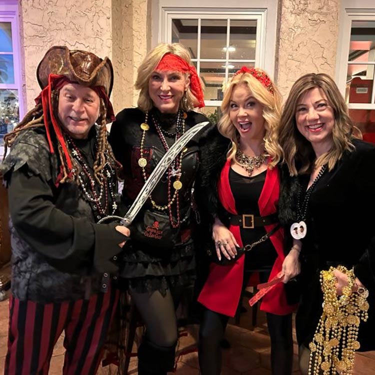 Four people are dressed in pirate costumes, posing for the camera.