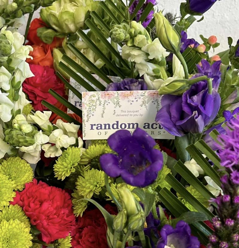 Close-up of a colorful flower bouquet with a Random Acts of Flowers delivery card