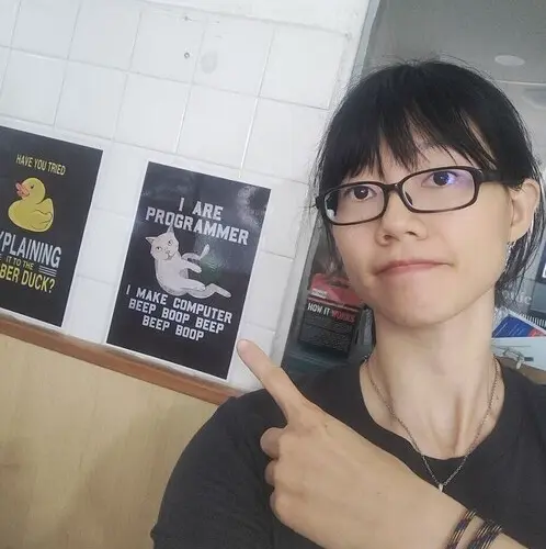 Hui Jing Chen pointing at a programming poster