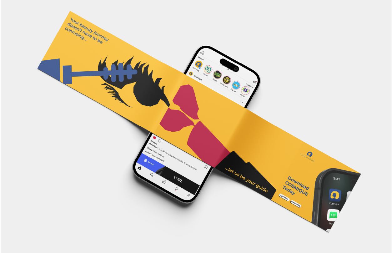 Folded yellow brochure with black and red abstract shapes, promoting the COSMIQUE app shown on a smartphone screen beneath it.