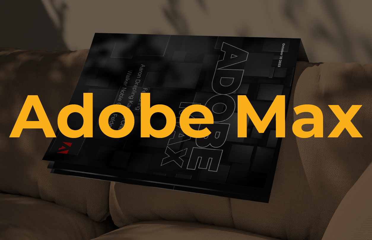 Stack of Adobe Max 2023 event booklets resting on a brown textured couch with a shadow pattern in the background.