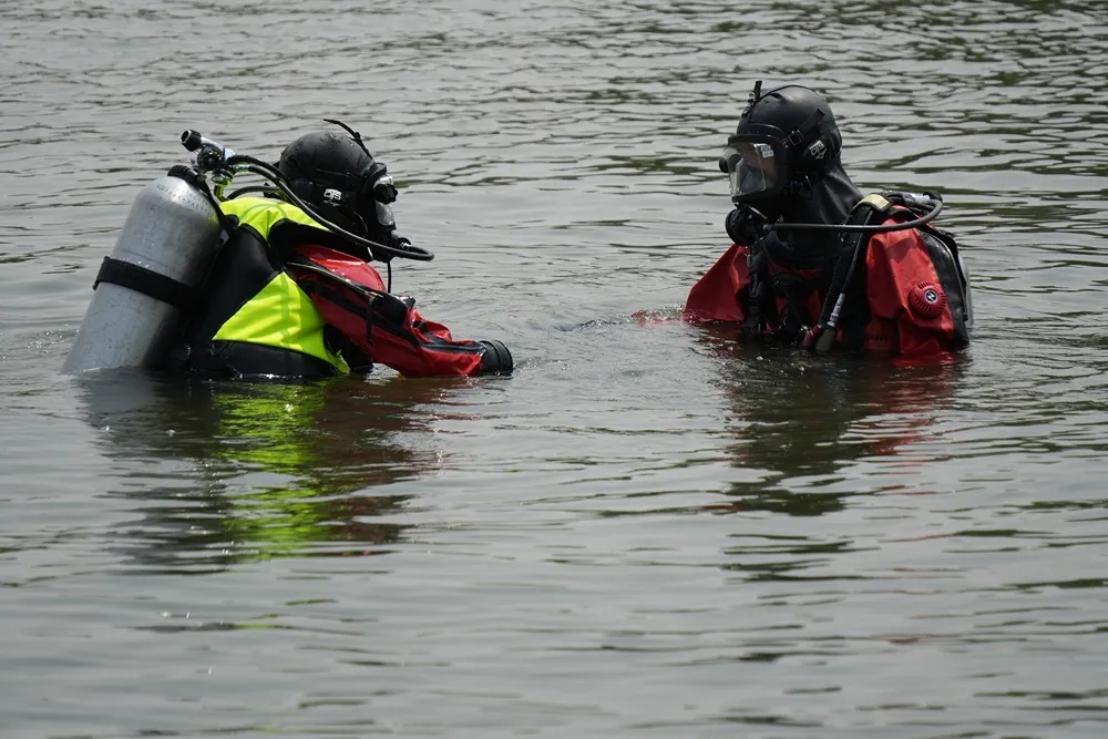 Two firefighters in diving gear conducting a water rescue training exercise