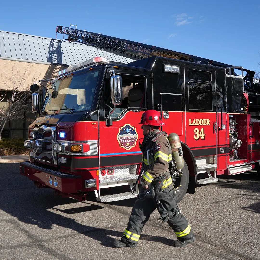 Firefighter standing with firetruck