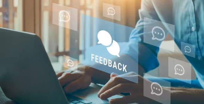 A person typing on a laptop with a message bubble above it.